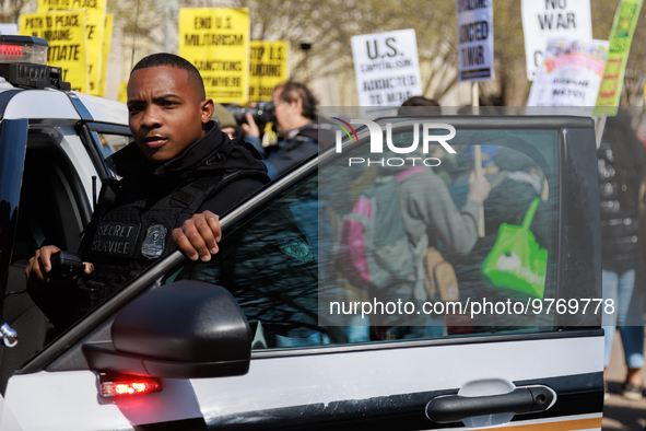 A United States Secret Service officer watches protestors during an anti-war protest in Washington, D.C. on March 18, 2023. The protest, org...