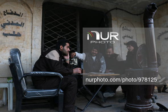 A group of Syrian civil defense sit around a fire in Aleppo on December 30,2015. 