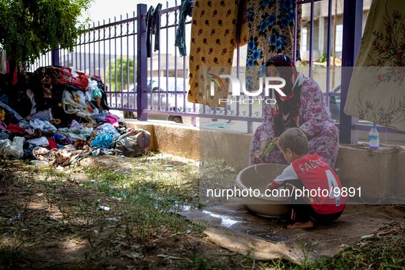 A mother with his child is doing the laundry and living between garbage bags in an open space without any shelter.

Photo: Flo Smith/NurPhot...