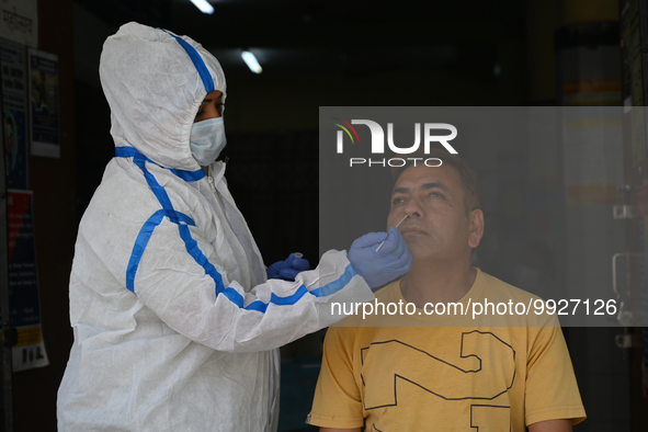 A healthcare worker collects a swab sample of a man for Covid-19 test, amid a rise in coronavirus cases in the country, in New Delhi on Apri...