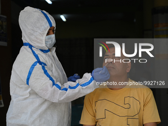 A healthcare worker collects a swab sample of a man for Covid-19 test, amid a rise in coronavirus cases in the country, in New Delhi on Apri...