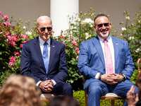 President Joe Biden and Secretary of Education Miguel Cardona sit on stage during an event honoring Teachers of the Year in the White House...